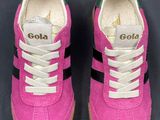 pink and black sneakers with white laces on them on a black surface