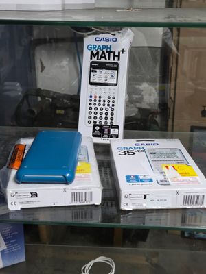 une vitrine en verre contenant une télécommande, un téléphone portable et d'autres appareils électroniques