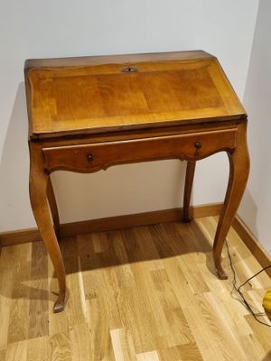 un petit bureau en bois sur lequel est posée une lampe