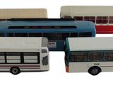 quatre petits bus qui sont rangés les uns à côté des autres