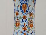 un vase bleu et orange posé sur une table en bois