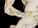 a figurine of a cupid holding a tea cup