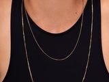 a woman wearing a black tank top and a gold chain necklace