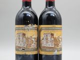 deux bouteilles de vin rouge posées l'une à côté de l'autre sur une surface blanche