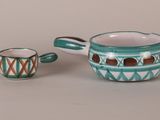 a cup and saucer sitting next to each other on a table