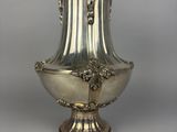 a silver vase that is sitting on a table