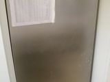 a silver refrigerator in the corner of a room