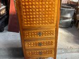 a tall wooden cabinet with a drawer on top of it