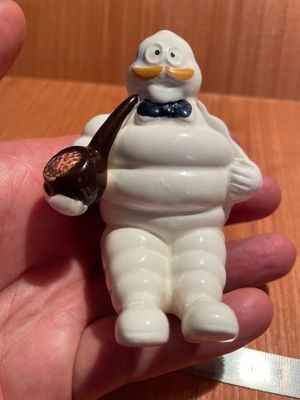 une petite figurine représentant un homme tenant une pipe à la main