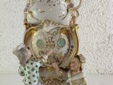 a figurine of a woman holding a baby on a clock
