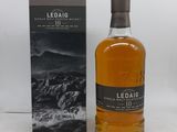 une bouteille de whisky posée sur une table à côté d'un coffret