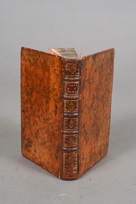 an old book sitting on top of a table next to a gray wall
