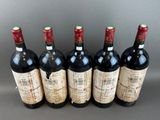 six bottles of wine are lined up in a row on a table