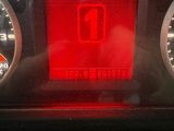 a close up of a car ' s dashboard with a red light