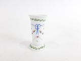 a white vase with a blue ribbon on it