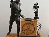 a statue of a man with a clock on a table
