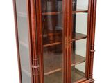 an image of a wooden display cabinet with glass doors and drawers