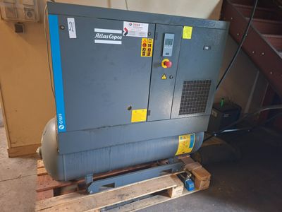un compresseur d'air posé sur une palette dans un garage