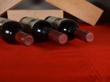 several bottles of wine are lined up on a red table cloth