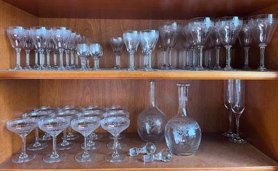 de nombreux verres et vases posés sur une étagère dans un meuble