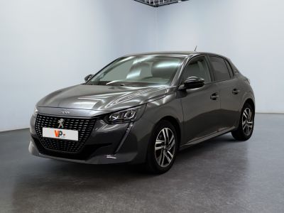 La voiture grise est garée dans une grande pièce au sol noir.