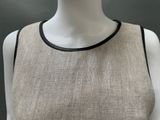 an image of a mannequin wearing a beige dress with black trims