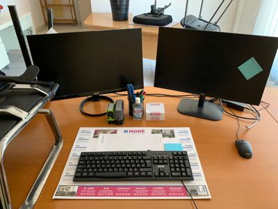un bureau sur lequel sont posés deux écrans d'ordinateur et un clavier