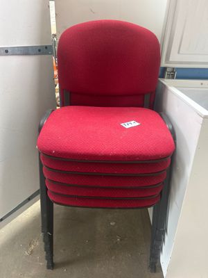 une chaise rouge qui se trouve à côté d'un réfrigérateur
