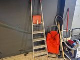 une échelle appuyée contre un mur, sur laquelle se trouve un sac rouge