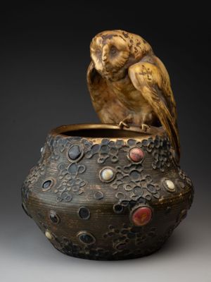 un oiseau perché sur un vase posé sur une table