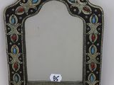an ornate mirror hanging on a wall with a tag on it