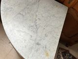 a table with a marble top in the corner of a room