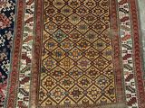 two rugs on the floor with a red chair in the background