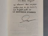 un livre ouvert, sur lequel figure une citation manuscrite, posé sur une table