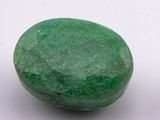 a close up of a green stone on a white surface