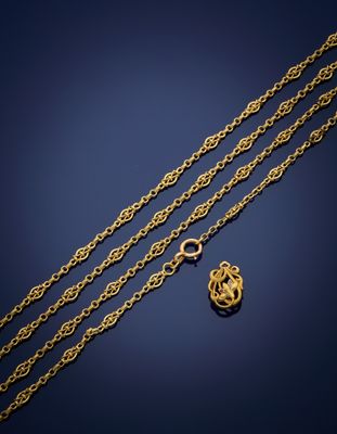 a close up of a gold chain with a heart charm on it