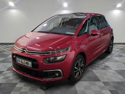 une citrole rouge garee sur un plancher en damier dans un garage