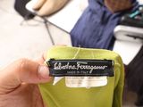 a person holding a green shirt with a label on it