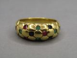 a close up of a gold ring with multi colored stones