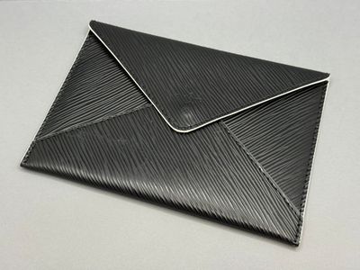 enveloppe en cuir noir avec des coutures blanches sur le dessus