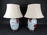 pair of red and white vase lamps with lampshads on black background