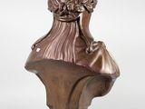a bronze bust of a woman with a hat on her head