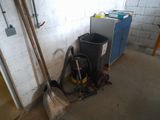 a picture of a room with a trash can and a vacuum in it