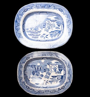 deux assiettes bleues et blanches ornées de motifs, posées sur un fond noir