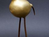 sculpture en bronze représentant un oiseau, posée sur un socle en bois