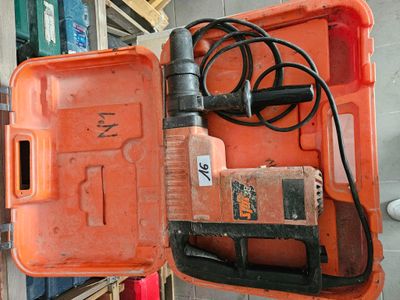une boîte orange contenant une perceuse et un cordon d'alimentation