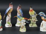 seven figurines of birds sitting on top of each other