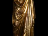 a gold statue of a woman holding a glass of wine