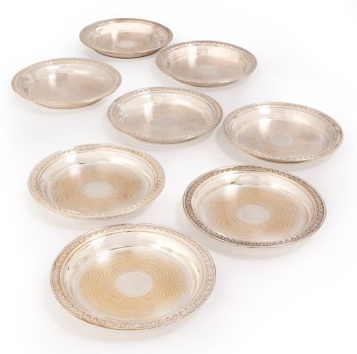 six silver plated bowls and a bowl on a white surface