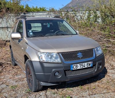a car that is parked in the dirt near a fence